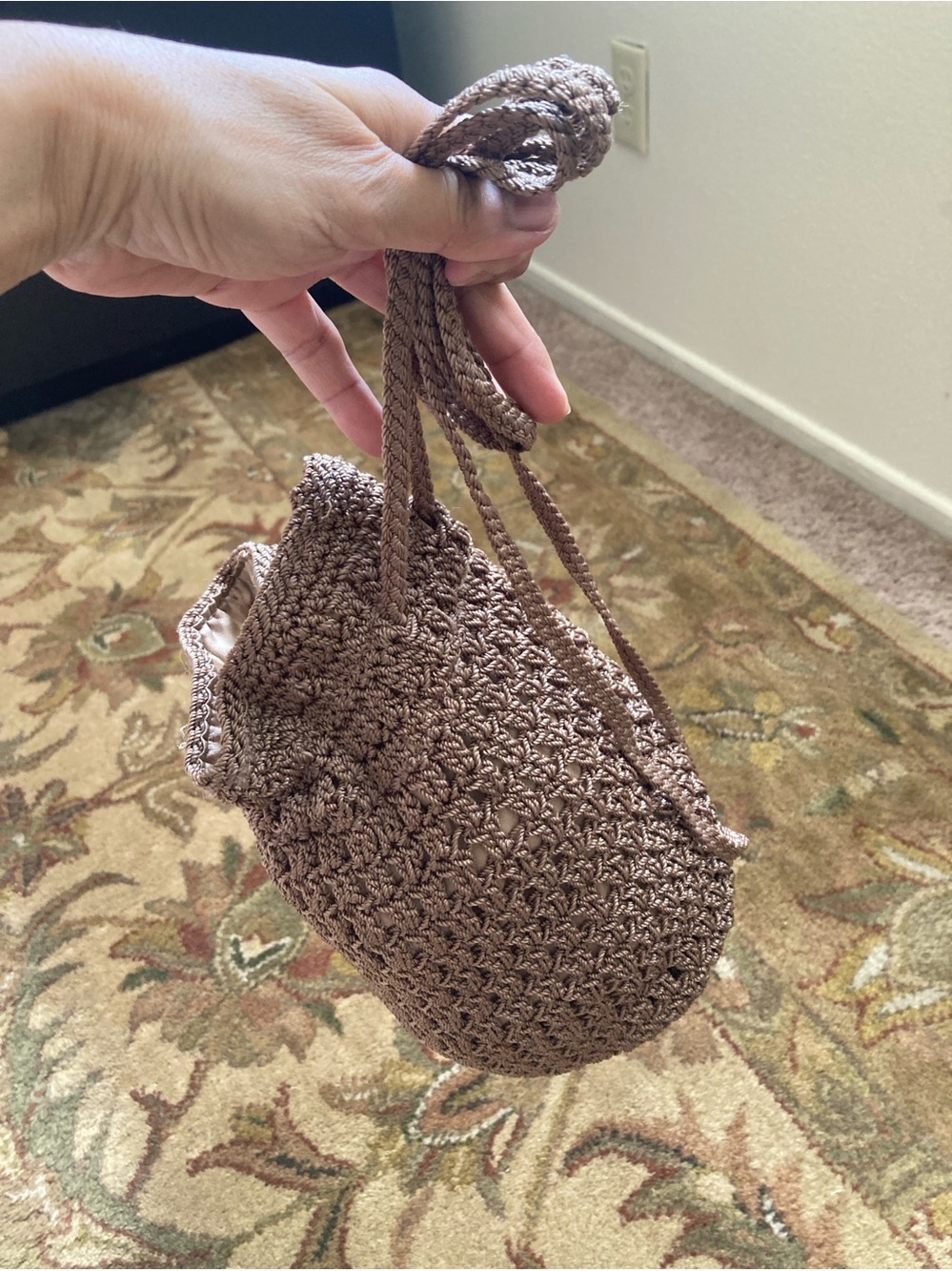 The saK metallic bronze crocheted drawstring pouch bag.